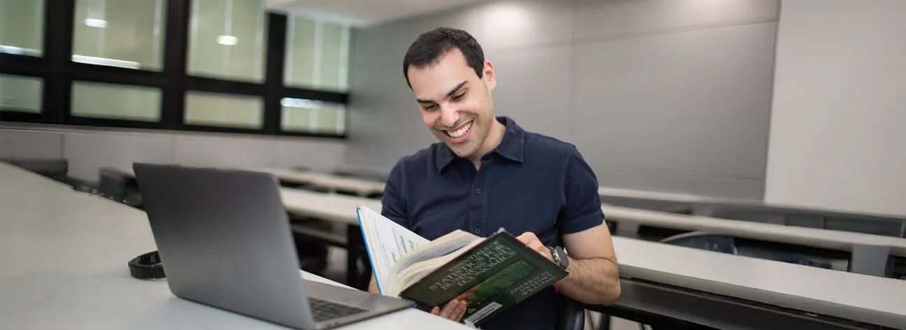 aluno em sala lendo livro