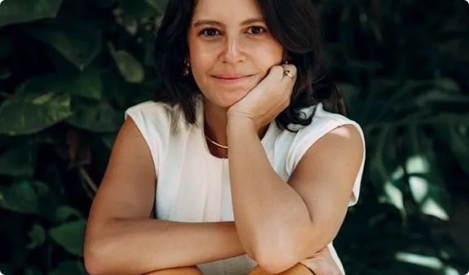 Mulher sentada sorrindo.