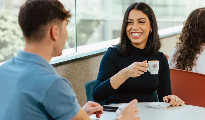 dois alunos conversando tomando café