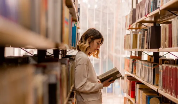 aluna estudando na biblioteca