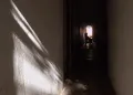 menina sentada em uma cadeira no fundo de um corredor