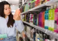 Consumidor analisa informações sobre sustentabilidade empresarial na embalagem de um produto.