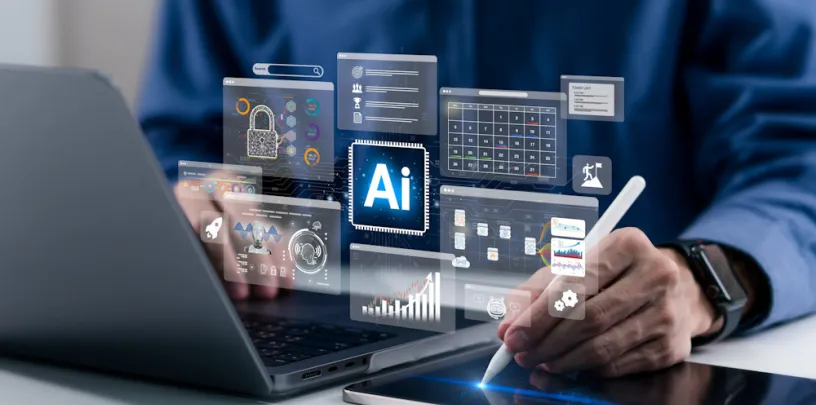 Pessoa utilizando um laptop e uma caneta digital em um tablet sobre a mesa, com diversos painéis virtuais sobrepostos representando inteligência artificial, análise de dados, segurança, calendário e gráficos. A cena remete ao uso de tecnologia avançada e IA em ambiente de trabalho corporativo.