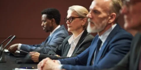 Mulheres na liderança em reunião executiva com equipe discutindo estratégias empresariais