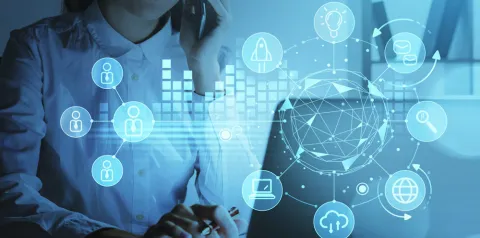 Profissional usando notebook e telefone com ícones digitais sobrepostos, representando comunicação, tecnologia e redes conectadas