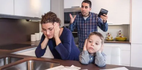 Família brasileira analisando contas e dívidas em casa, representando o superendividamento das famílias no Brasil
