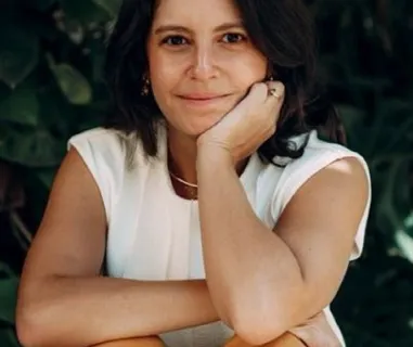 Mulher sentada sorrindo.